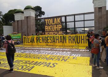 Foto: beberapa massa aksi dan spanduk besar saat menolak RKUHP di depan Gedung DPR/MPR RI, Jakarta, Senin (5/12/2022)